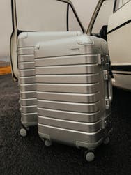 An aluminum carry-on suitcase paired with a medium checked size in silver