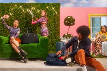 From left to right, a woman taking a selfy sitting next to an Away travel bag in black, a woman trimming backyard hedges, a man sitting on the steps opening his Away travel backpack, with a suitcase behind him, and a woman sitting and reading next to her aluminum suitcase