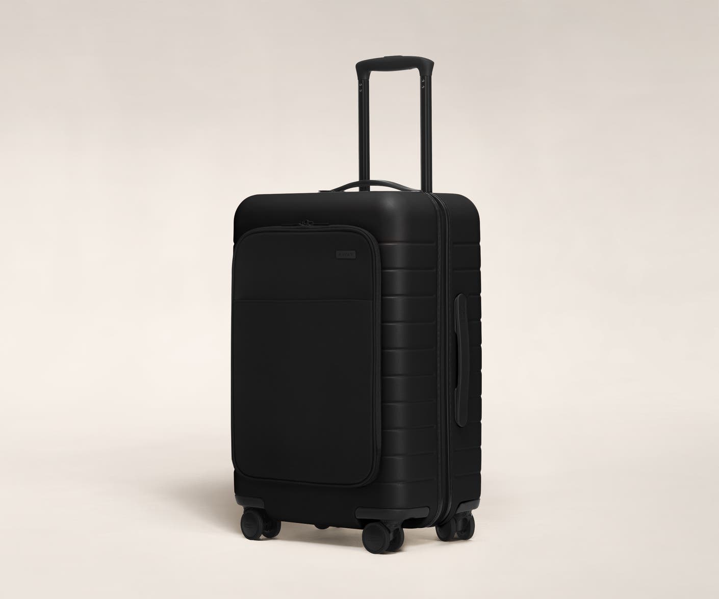 The Bigger Carry-On with Pocket in Black shown at an angle with raised telescoping handle