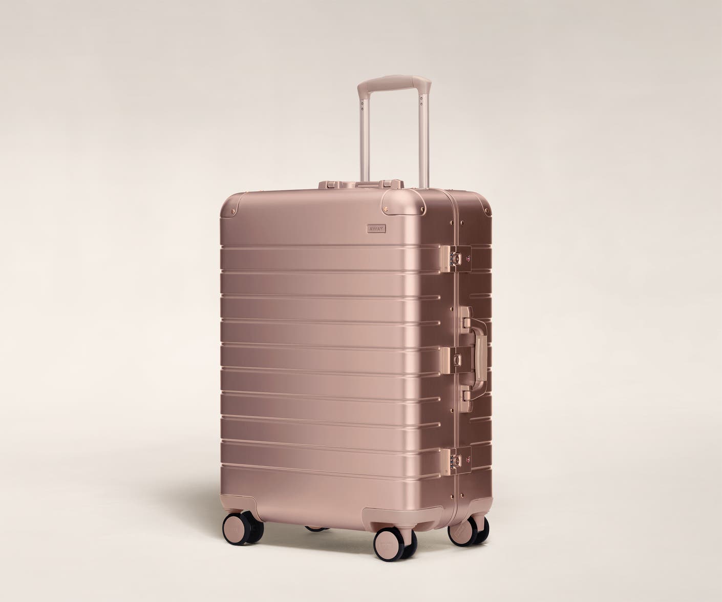 Aluminum checked luggage The Medium suitcase in rose gold with raised handle
