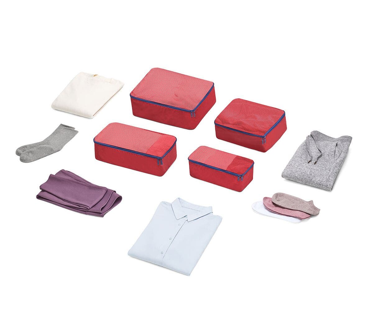 Set of four packing cubes in red with clothes displayed around it