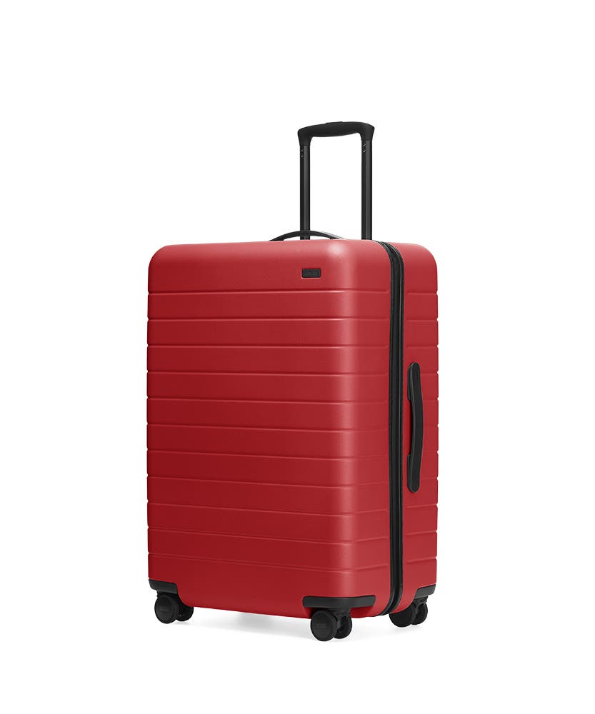 Red hardside Medium with raised telescopic handles shown at an angle.
