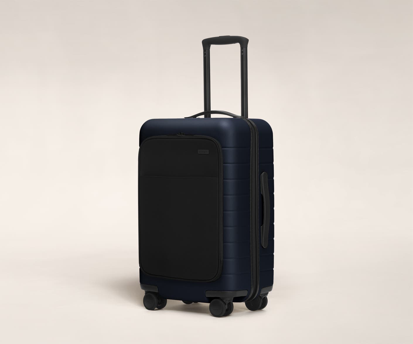 The Carry-On with Pocket in Navy shown at an angle with raised telescoping handle