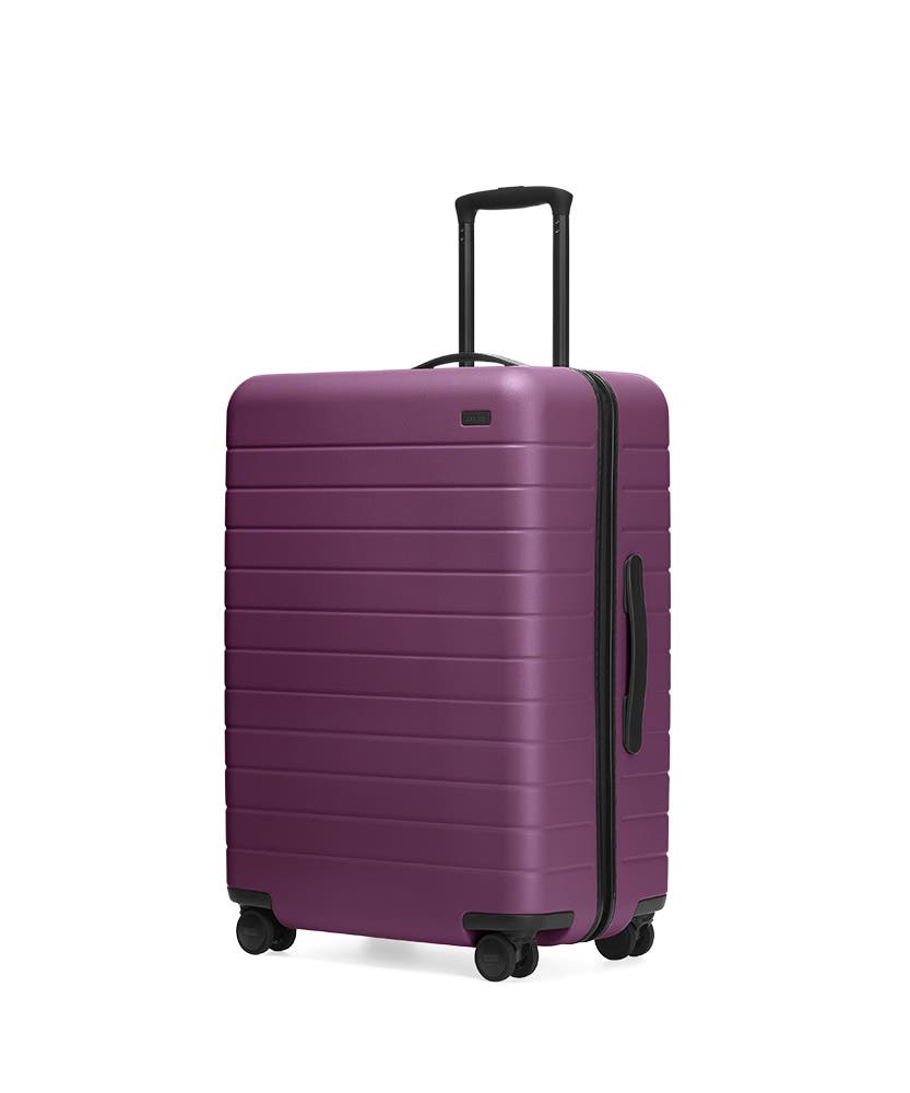 The Plum Medium hardside with raised telescopic handles shown at an angle.
