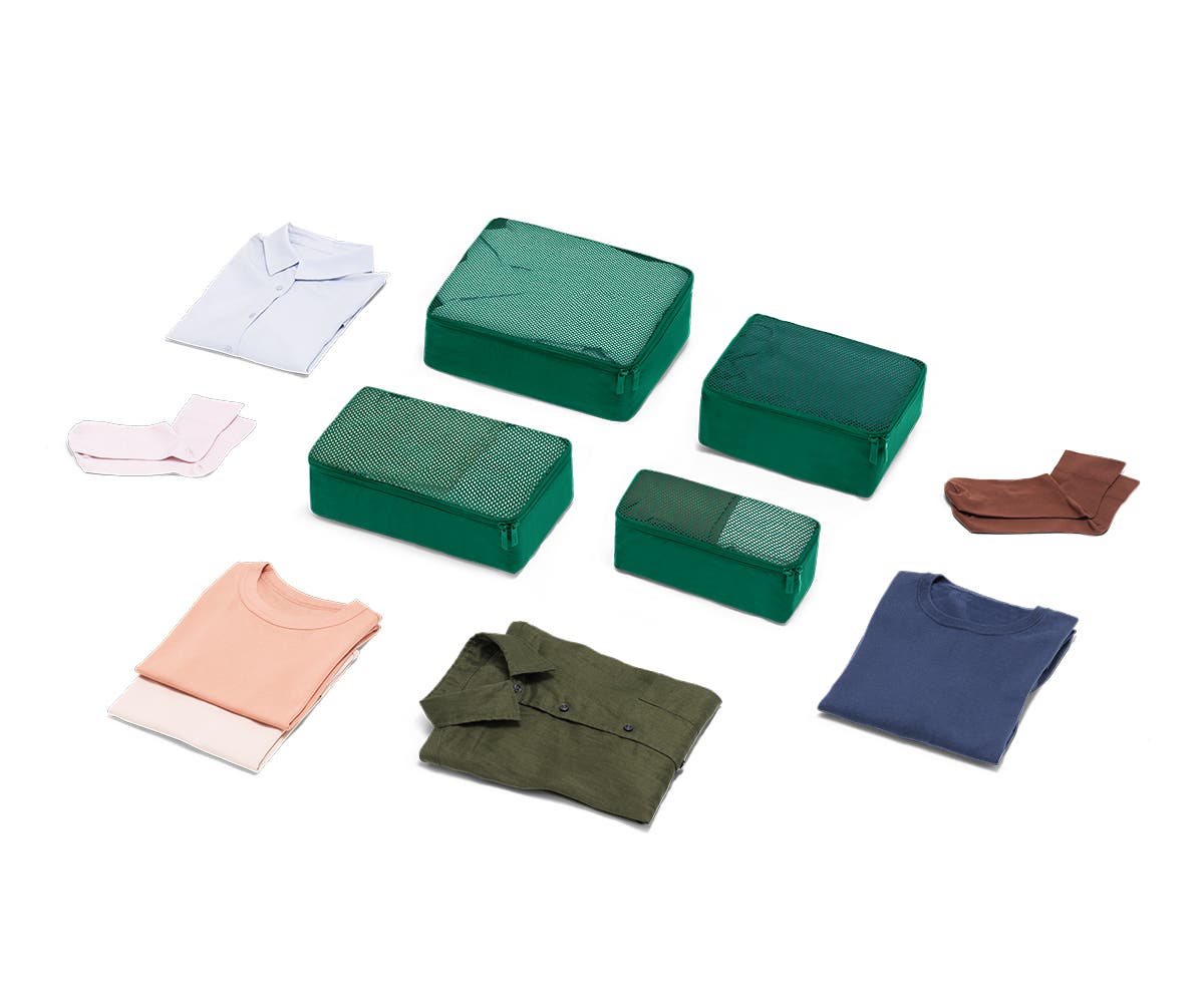 Set of four packing cubes in Sea-green with clothes displayed around it