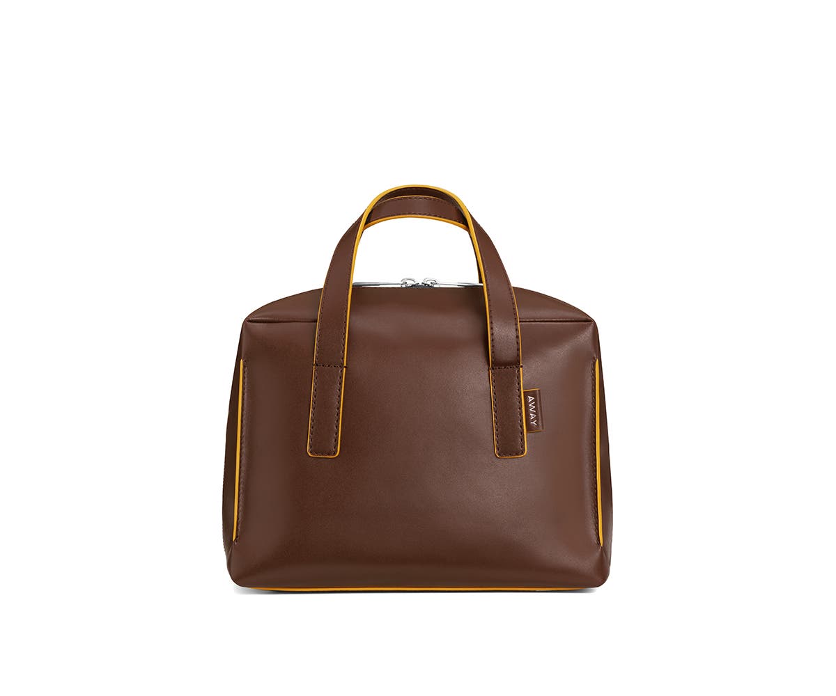 Chestnut mini travel bag with handle straps raised vertically.