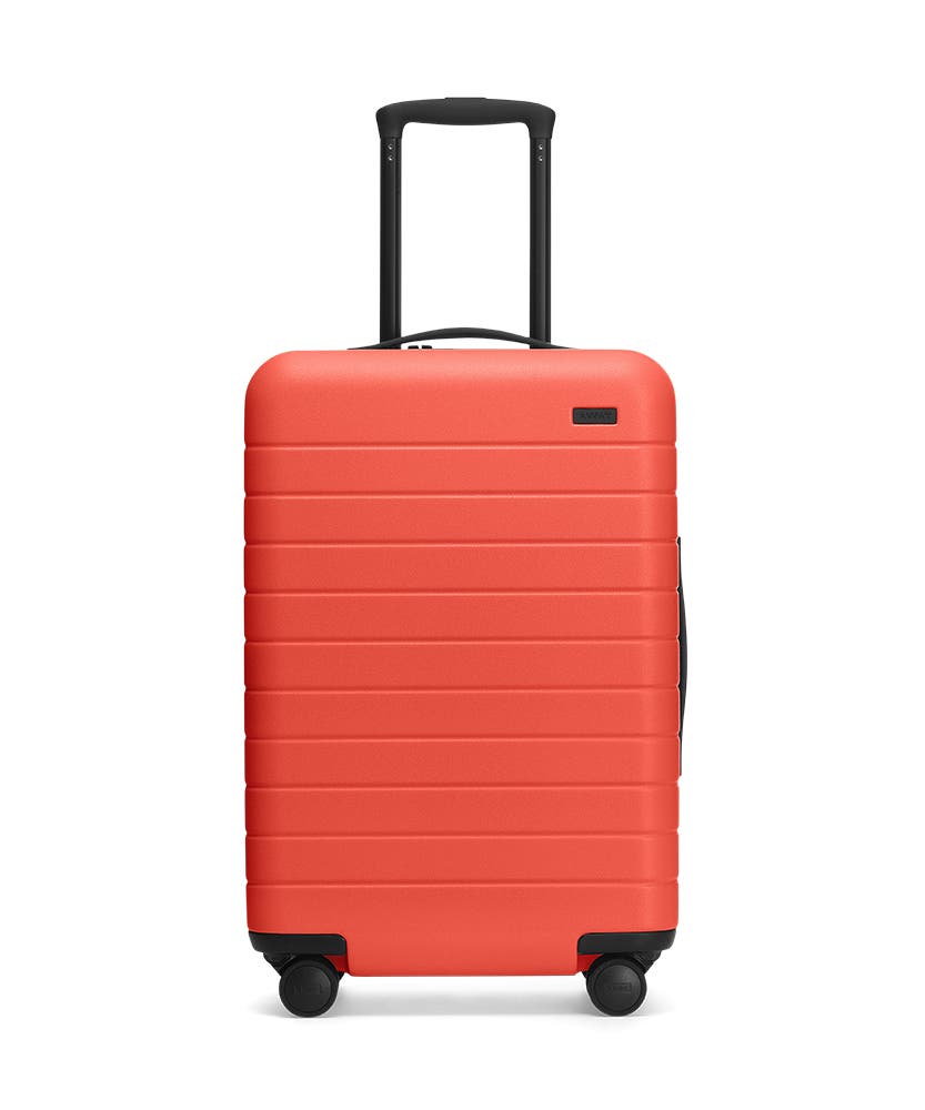 Front view of the Away Coral Bigger Carry-On hardside showing raised handle.