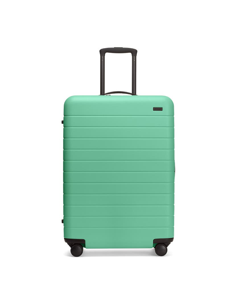 Front view of the Away Aqua Medium hardside showing raised handle.