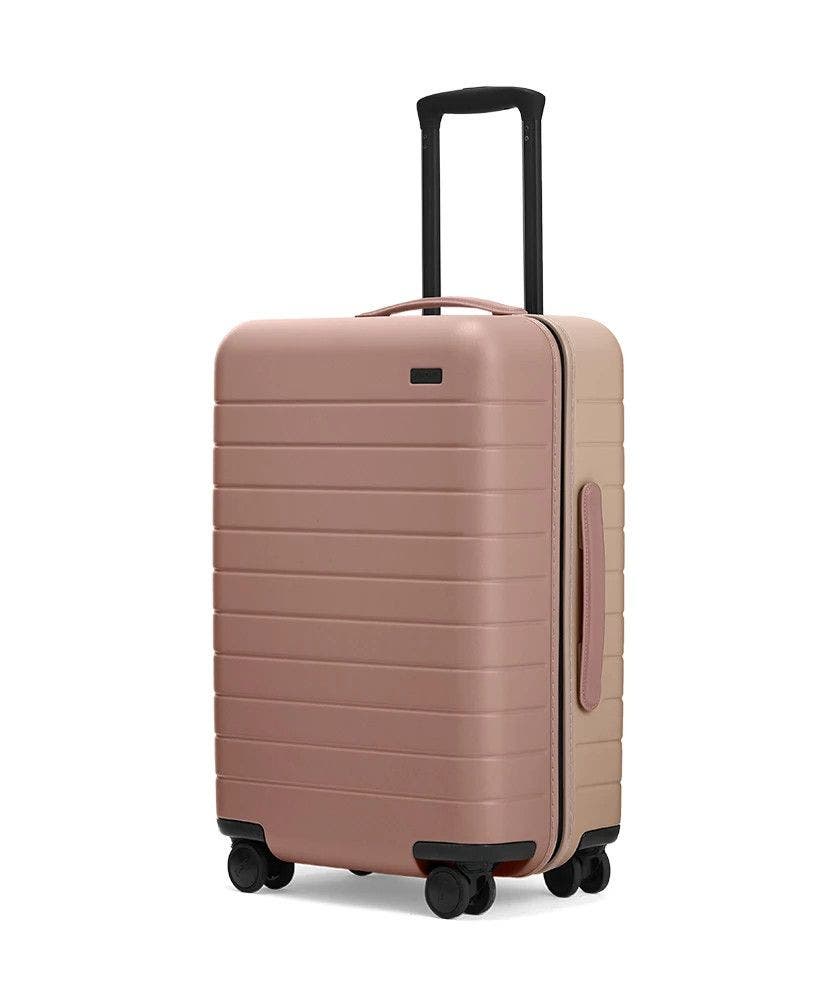 Dusty Rose/ Taupe Bigger Carry-On hardside with raised telescopic handles shown at an angle.