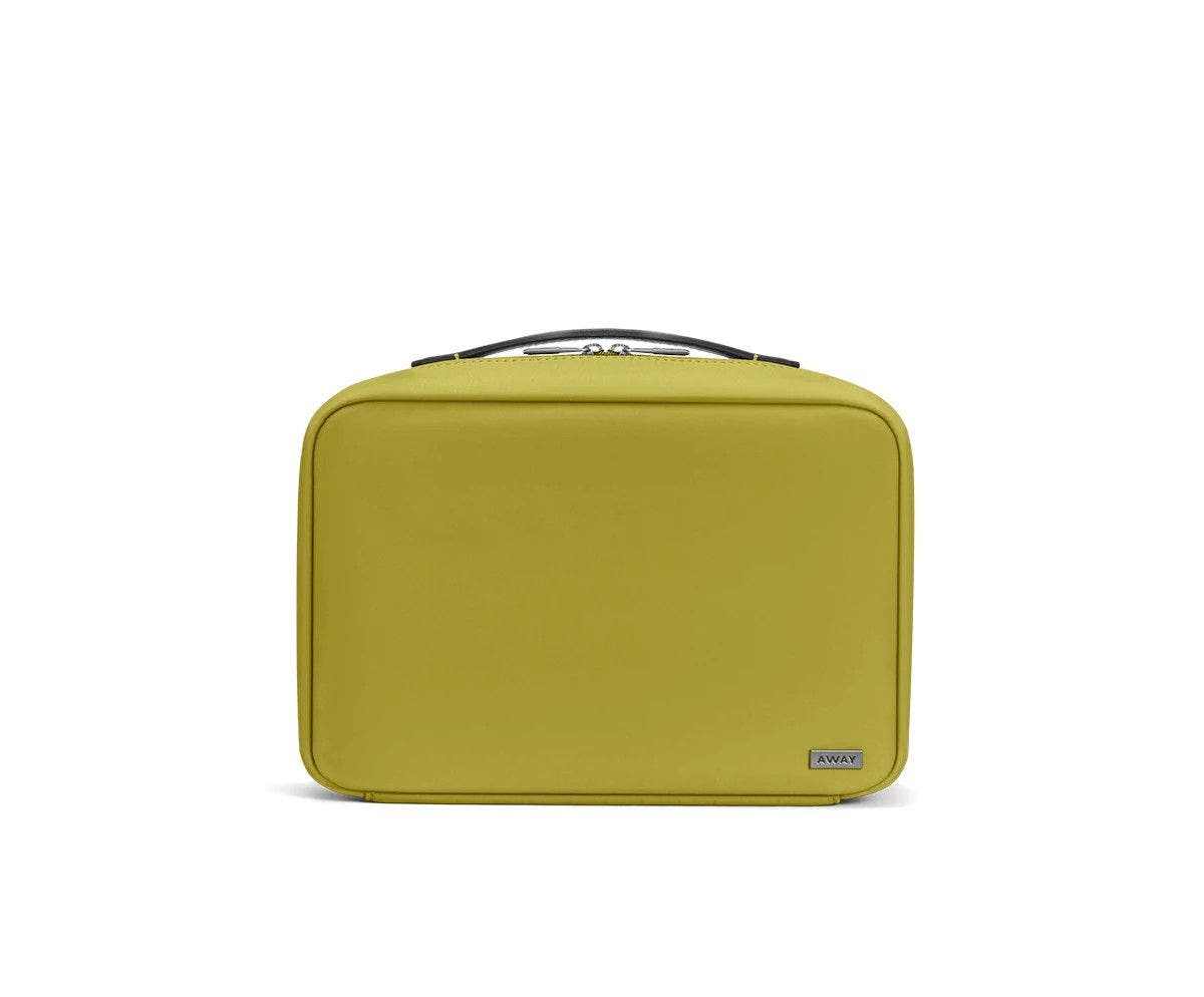 Front view of a pistachio green toiletry bag with handle on top.