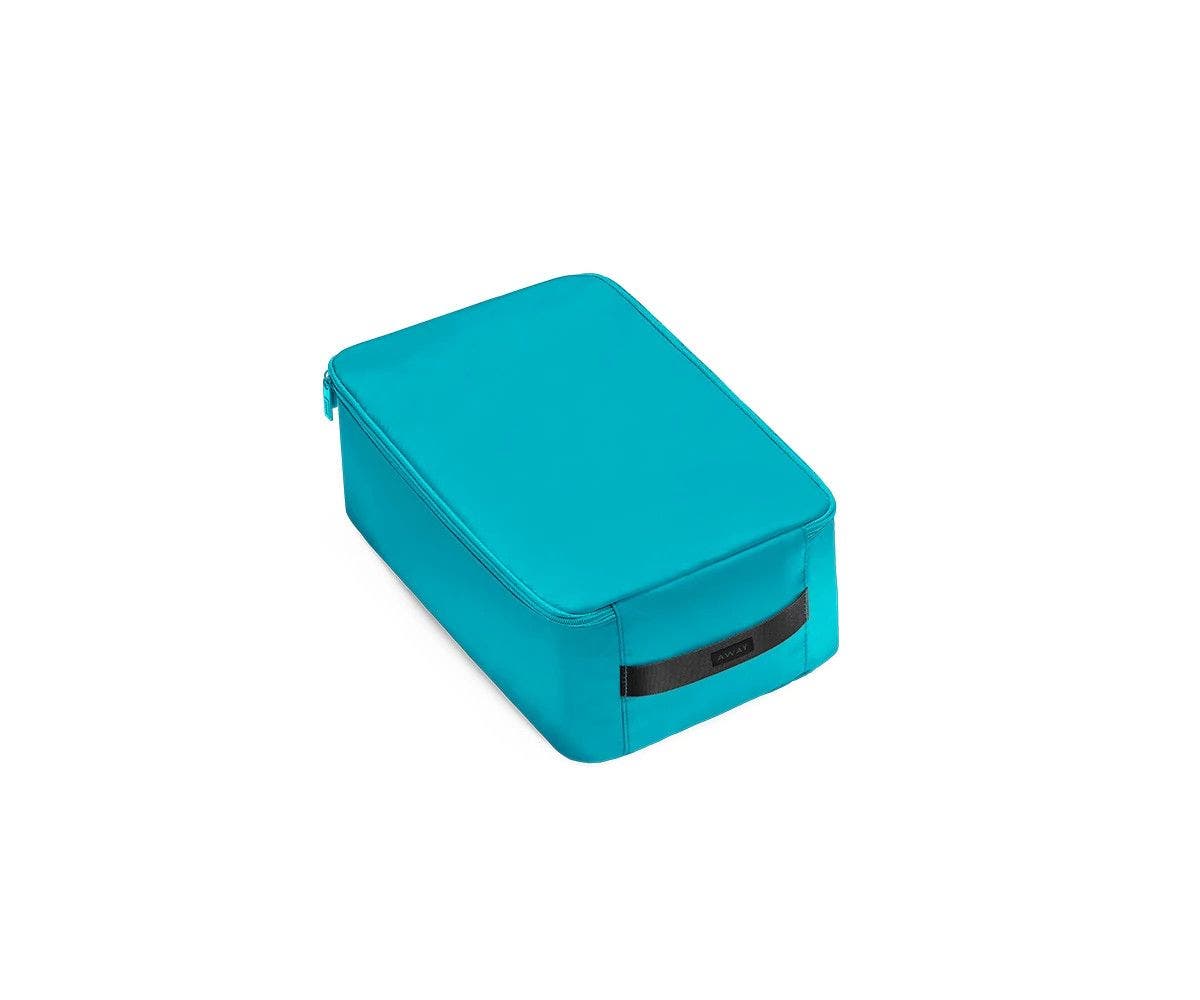 A angled view of a small bright teal shoe cube.