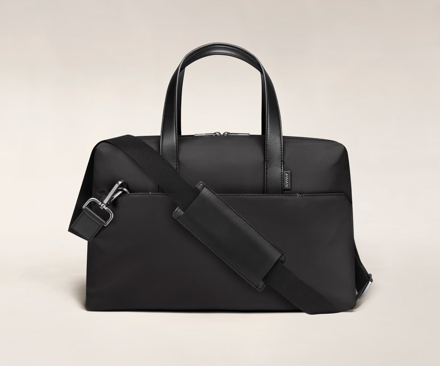 Black duffle with back zip pocket, and shoulder strap across the bag.