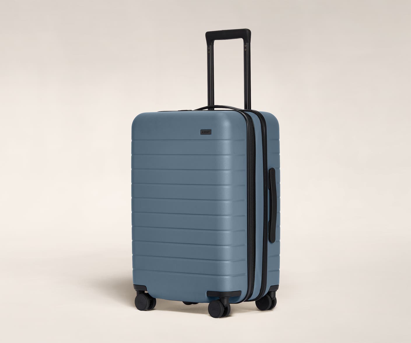 The Bigger Carry-On Flex in Coast shown at an angle with raised telescoping handle.