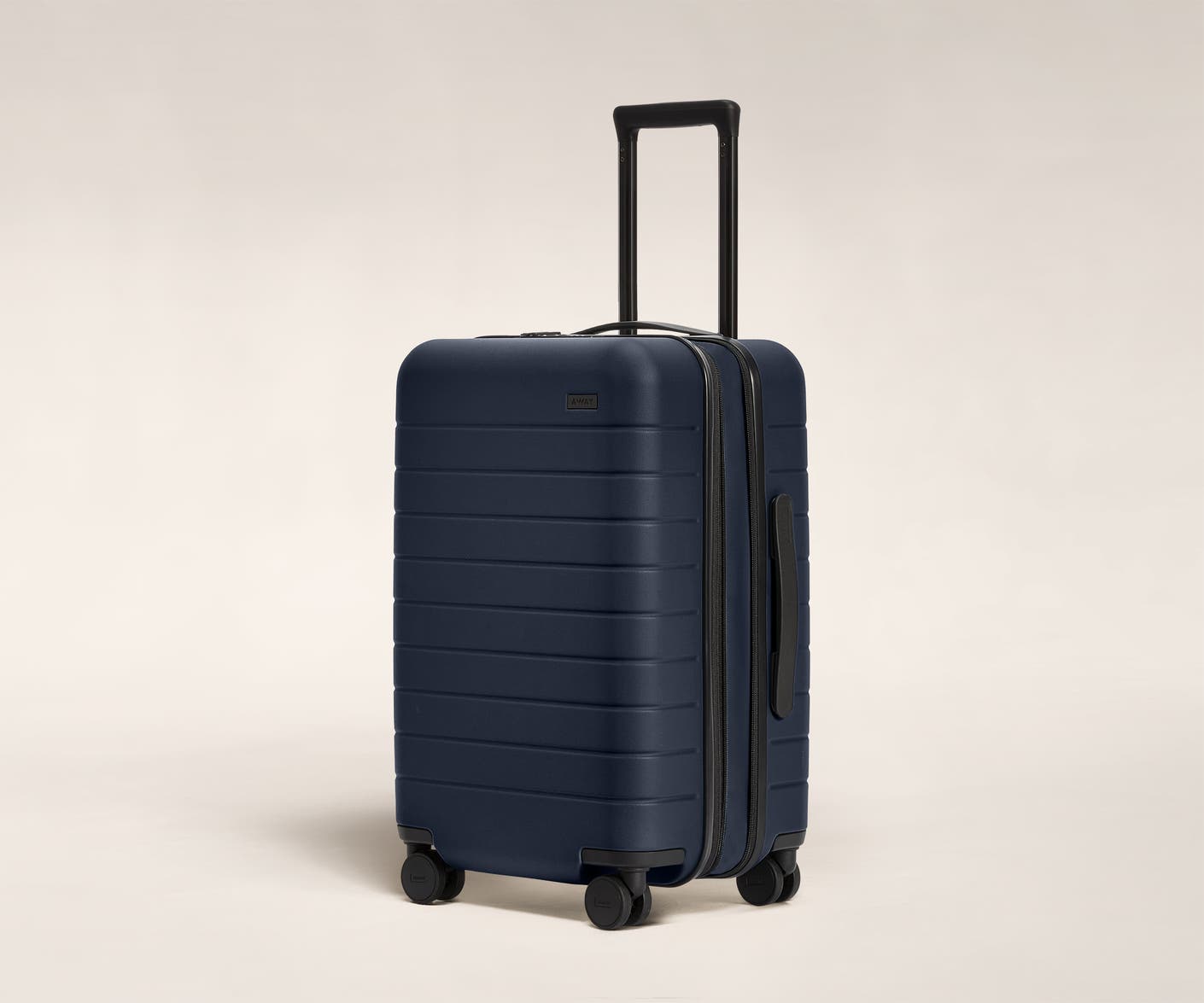 The Carry-On Flex in Navy shown at an angle with raised telescoping handle.