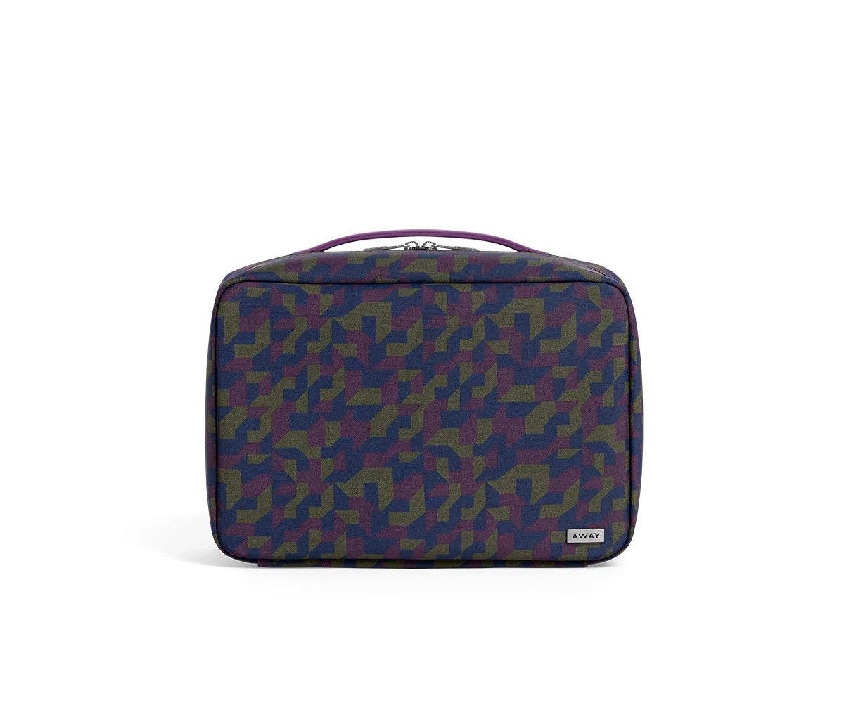 Front view of a geometric print toiletry bag with handle on top.