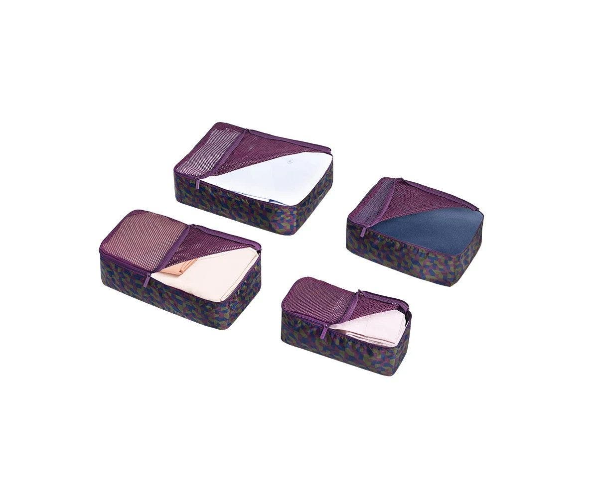 Set of four packing cubes in geometric print with clothes in it