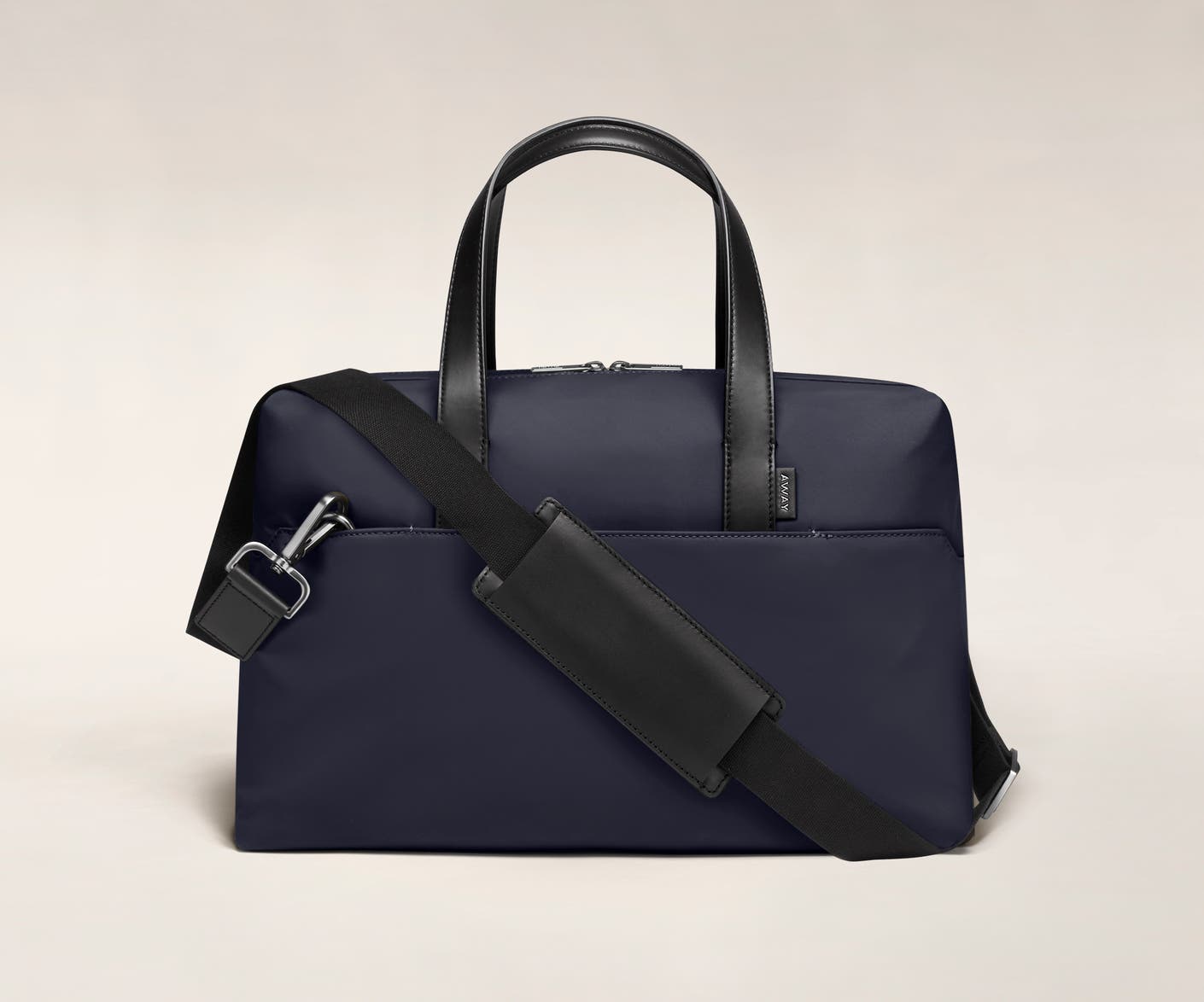 Navy duffle with back zip pocket, and shoulder strap across the bag.