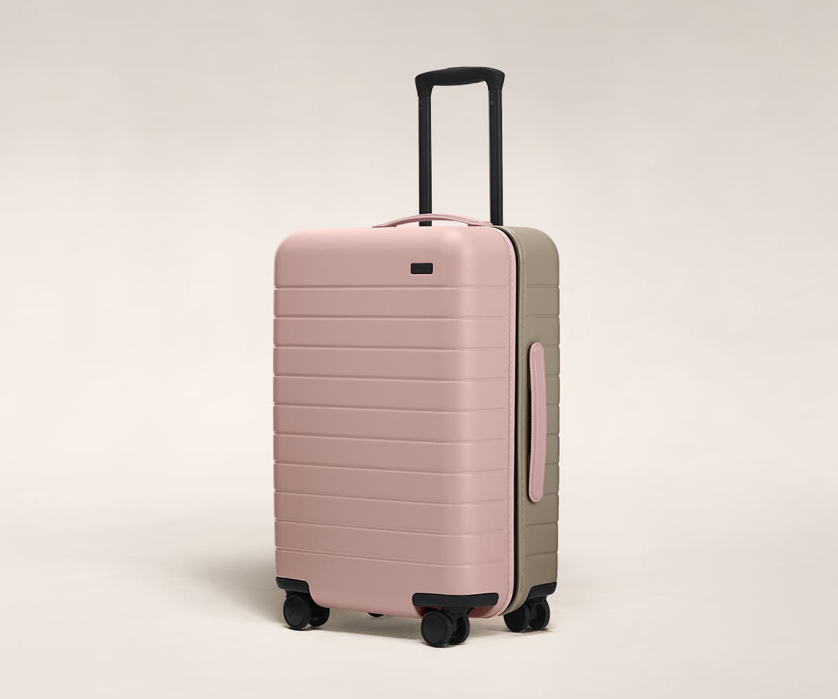 Petal/Sand Bigger Carry-On with raised telescopic handles shown at an angle.