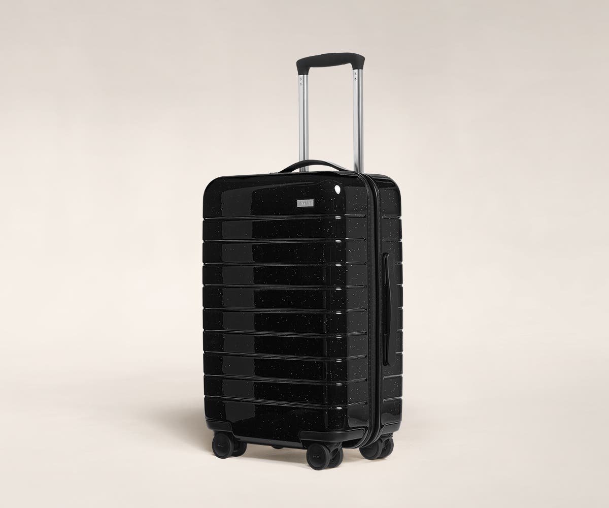 A black sparkle Carry-On with raised telescopic handles shown at an angle.