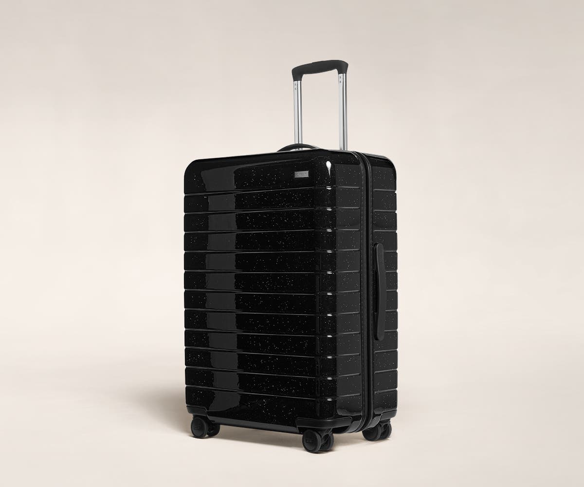 A black sparkle Medium with raised telescopic handles shown at an angle.