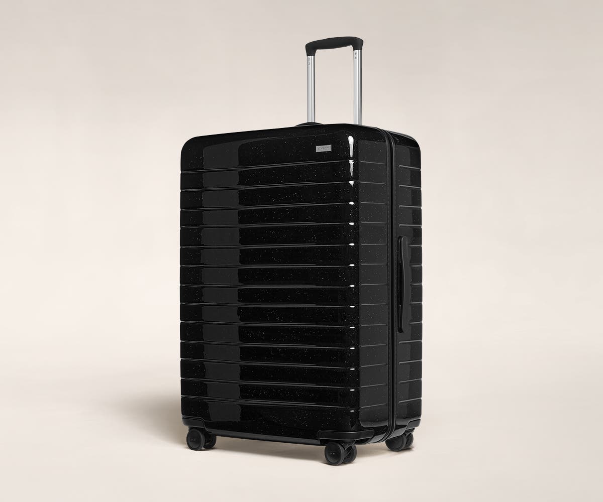 A black sparkle Large with raised telescopic handles shown at an angle.