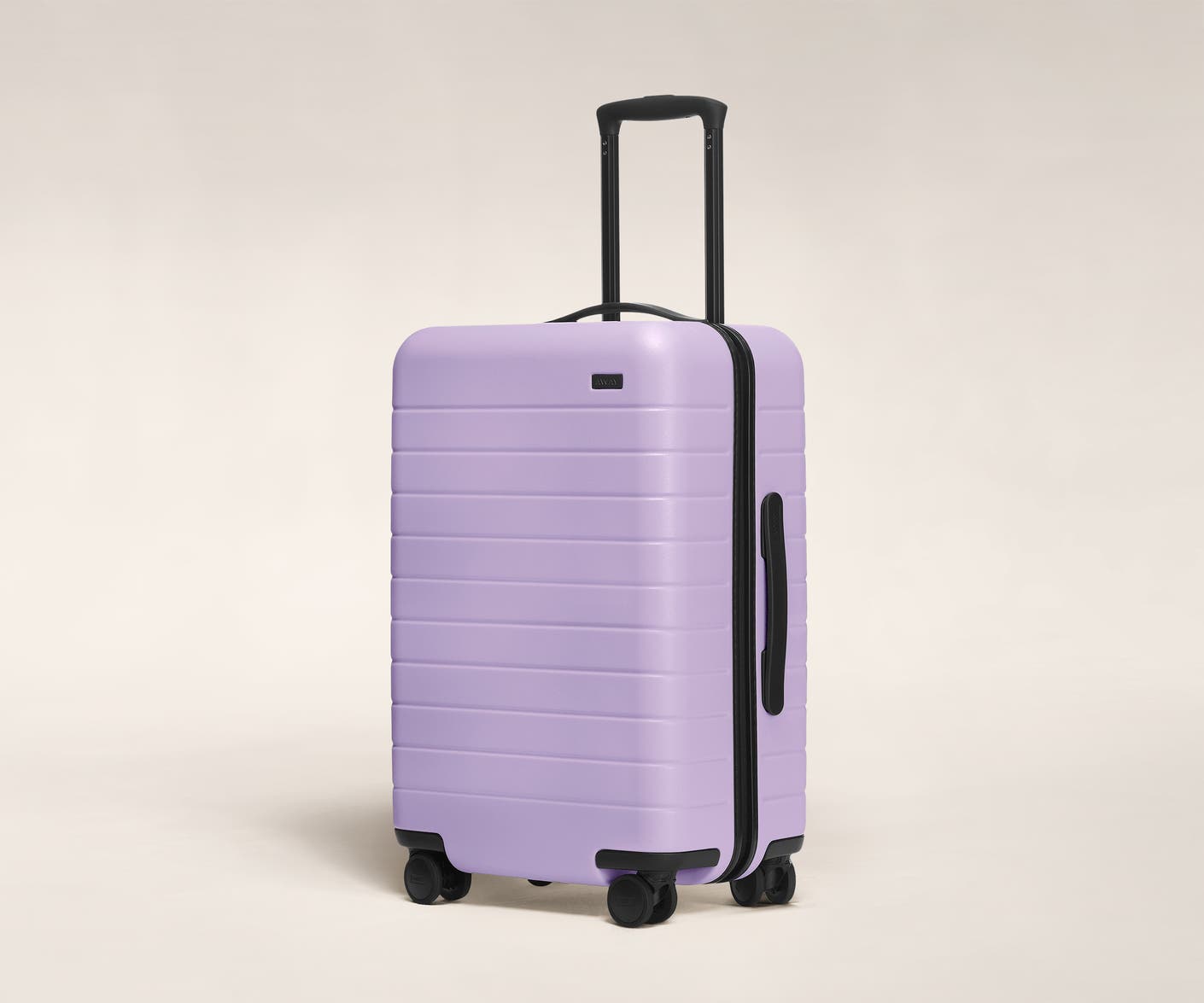 The Bigger Carry-On in Navy shown at an angle with raised telescoping handle