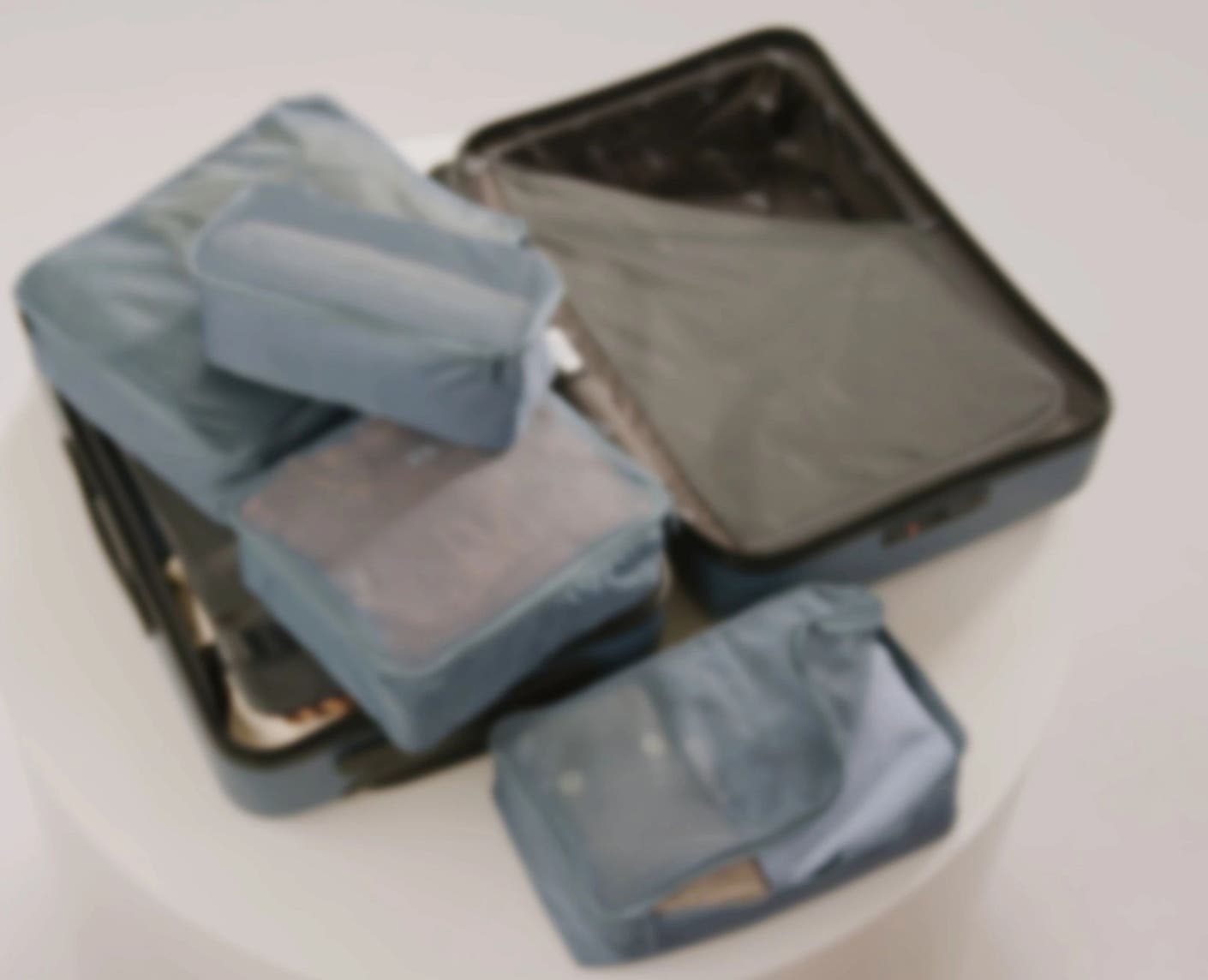 Packing Cubes in a set of four being packed into an Away suitcase.
