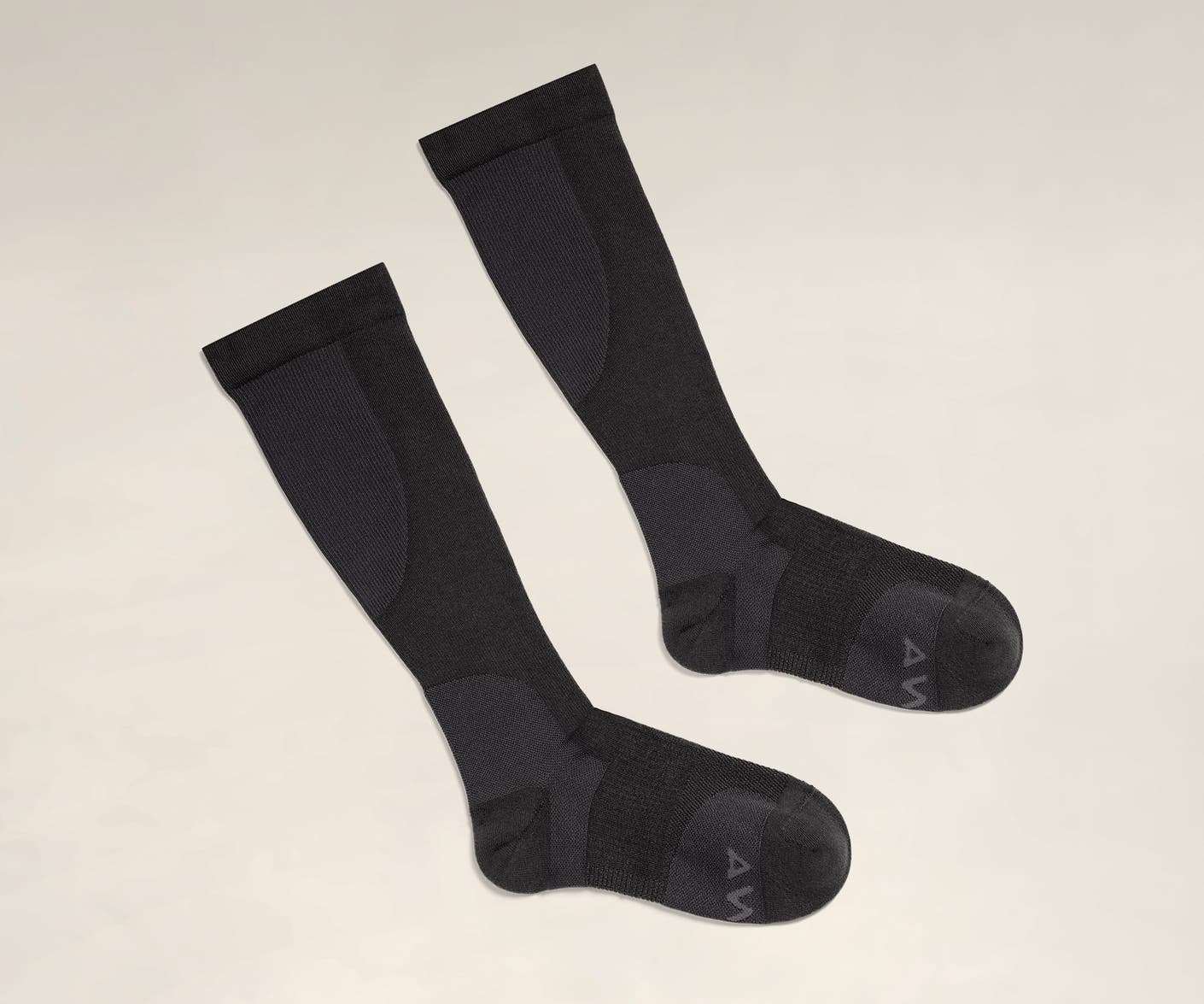 A pair of black travel compression socks.