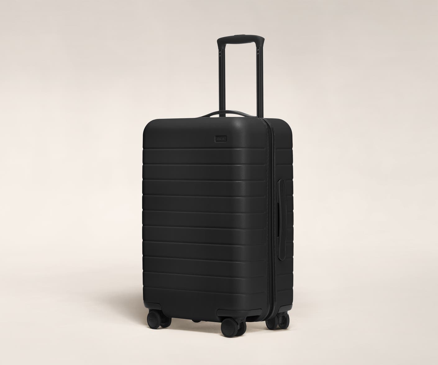 The Bigger Carry-On in Black shown at an angle with raised telescoping handle