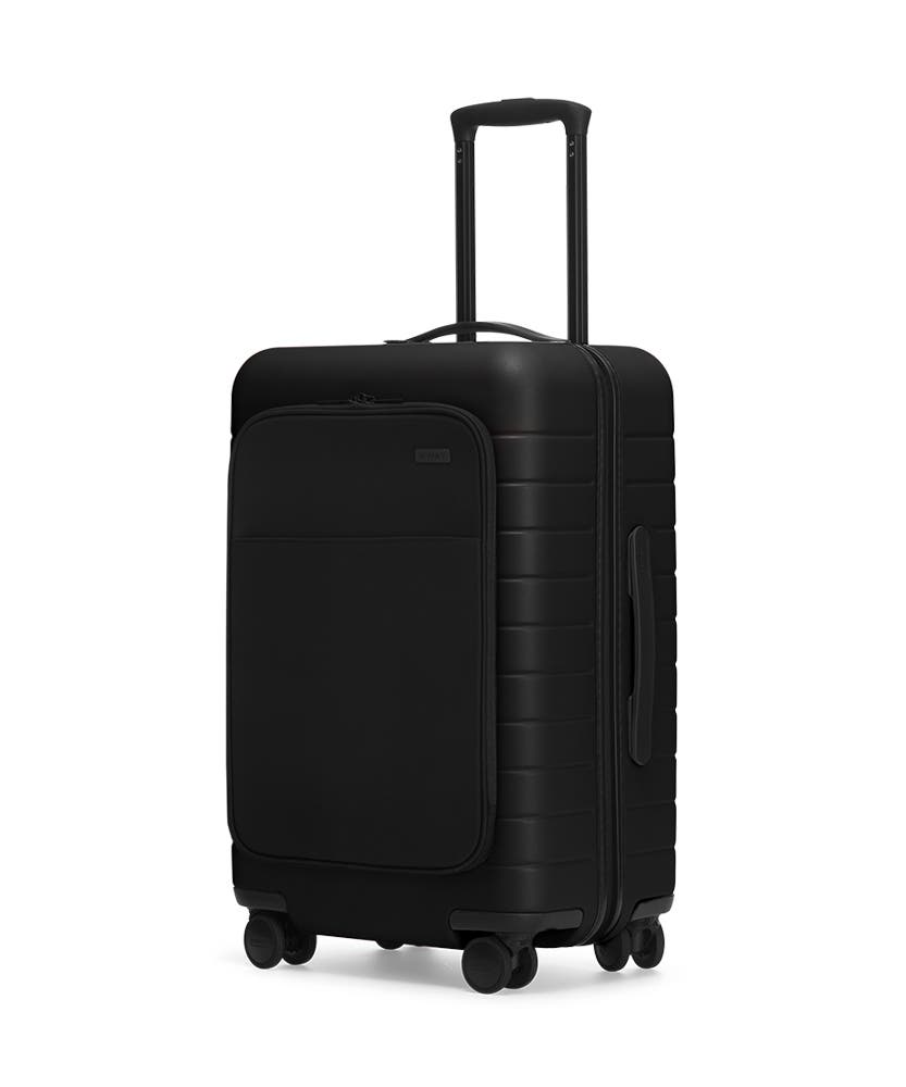 The Bigger Carry-On with Pocket in Black shown at an angle with raised telescoping handle