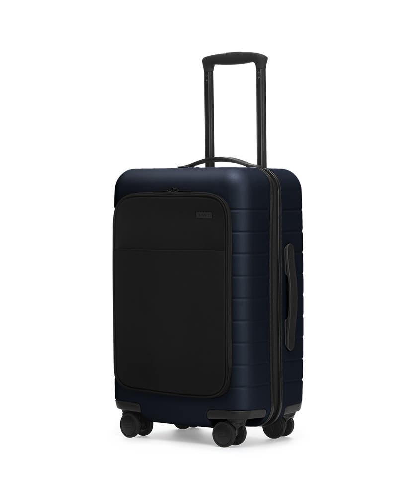 The Carry-On with Pocket in Navy shown at an angle with raised telescoping handle