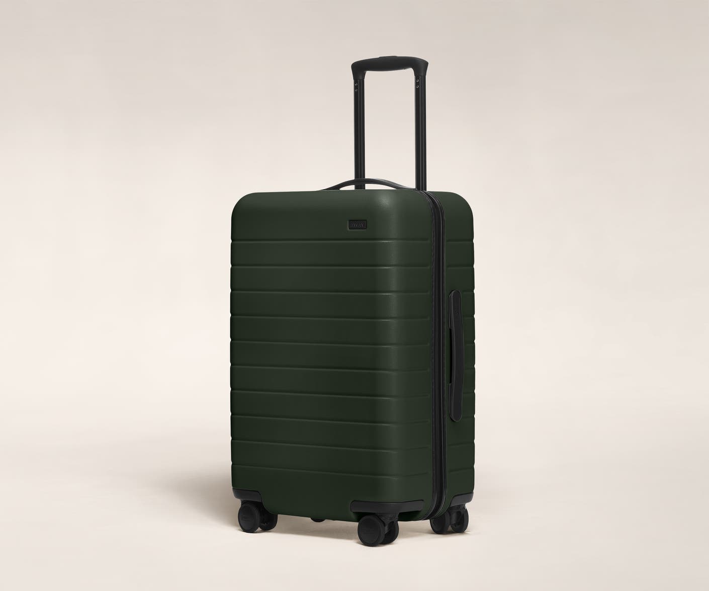 The Bigger Carry-On in Green shown at an angle with raised telescoping handle
