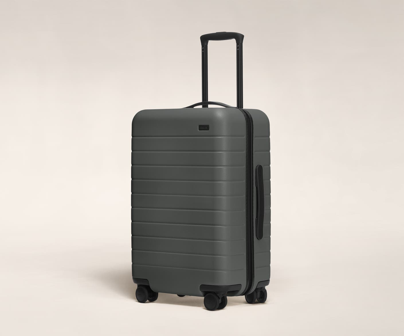 The Bigger Carry-On in Asphalt shown at an angle with raised telescoping handle