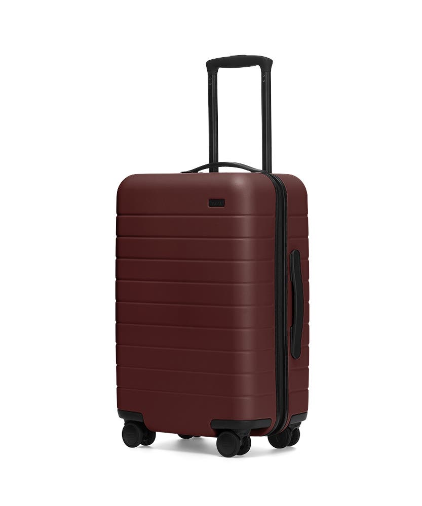 The Carry-On in Brick shown at an angle with raised telescoping handle
