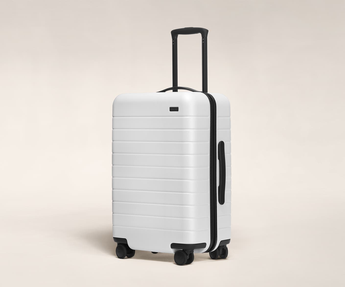 The Bigger Carry-On in White shown at an angle with raised telescoping handle