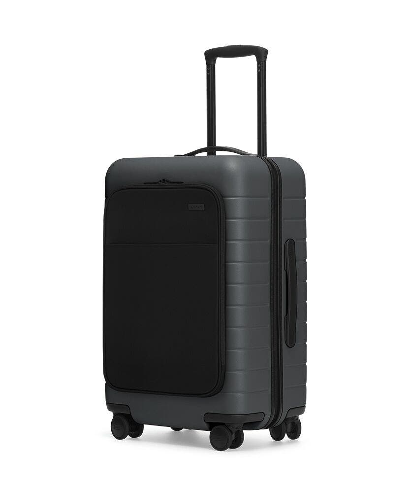 The Bigger Carry-On with Pocket in Asphalt shown at an angle with raised telescoping handle