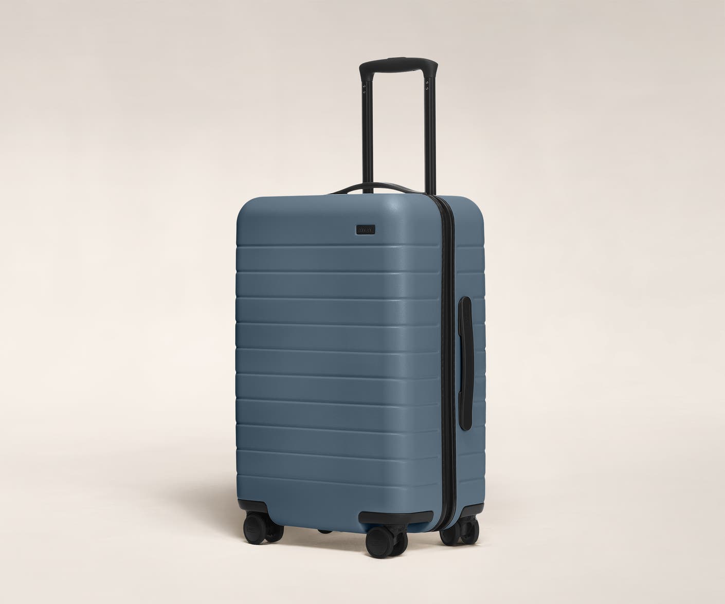 The Bigger Carry-On in Coast shown at an angle with raised telescoping handle